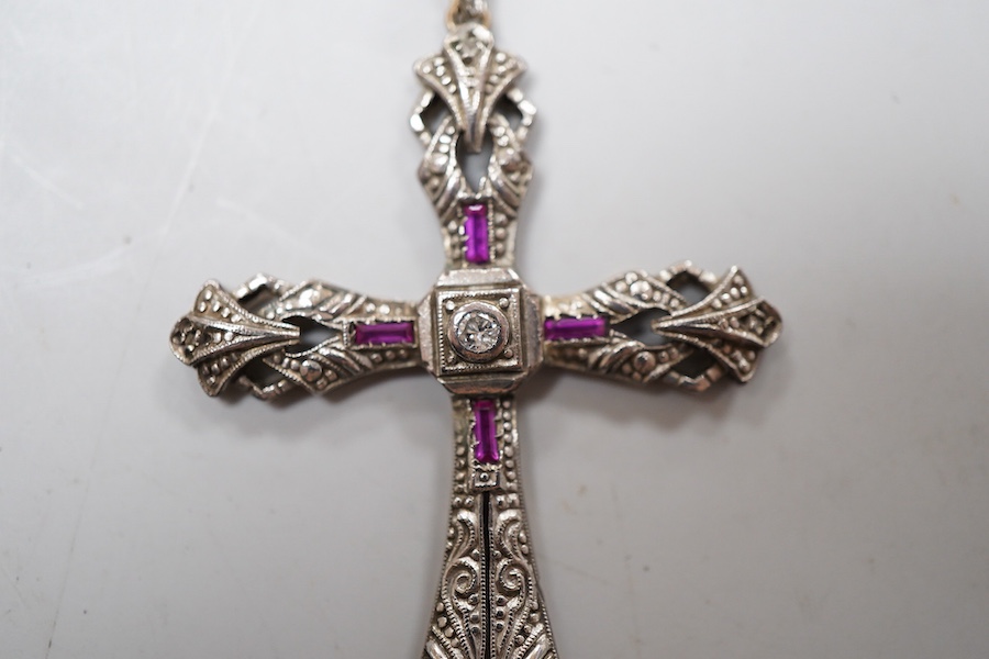 A synthetic ruby and diamond pendant, designed as a foliate cross, set with a brilliant-cut diamonds and step-cut synthetic rubies, on a chain necklace, mounted in gold, pendant length 5.4cm, stamped 18K, necklace length